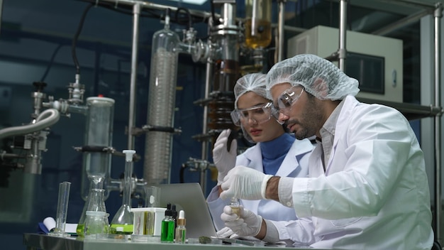 Twee wetenschappers in professioneel uniform werken in laboratorium