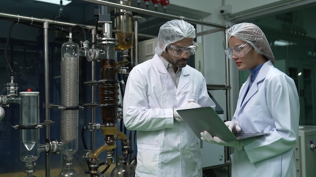 Twee wetenschappers in professioneel uniform werken in laboratorium