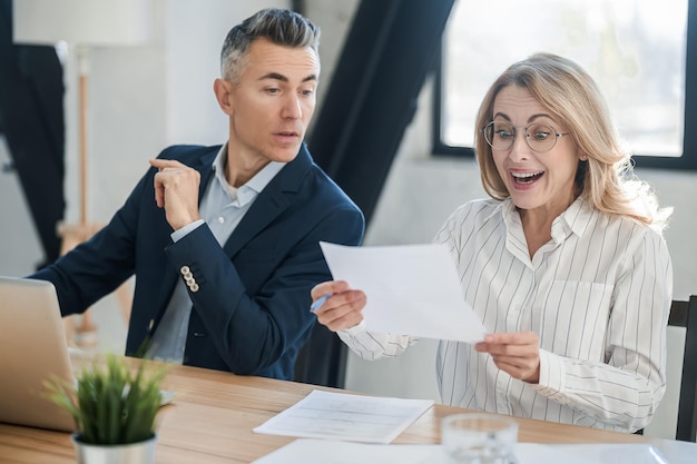 Twee zakencollega's die goed nieuws bespreken en er opgewonden uitzien