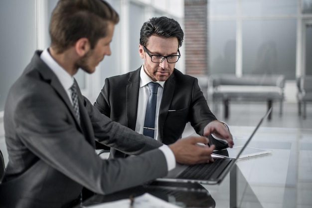 Twee zakenlieden bespreken informatie van een laptop