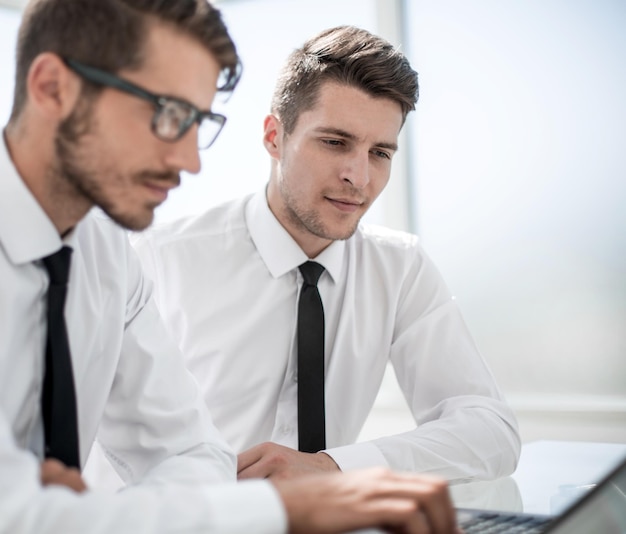 Twee zakenlieden werken op een laptop op tafel