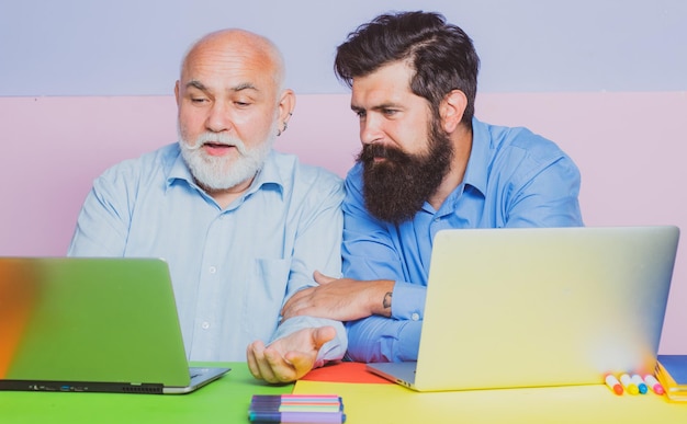 Twee zakenman die aan tafel zit te typen op een laptopcomputer die werkt met een nieuw businessplan Twee zakenmannen Kantoorpersoneel