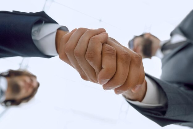 Twee zakenmensen houden handen vast aan zakelijke samenwerking