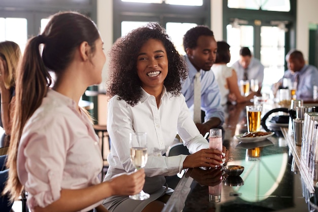 Twee zakenvrouwen ontmoeten elkaar voor een drankje na het werk in de bar