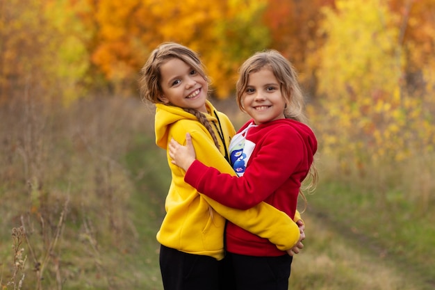 twee zussen knuffelen in het herfstpark