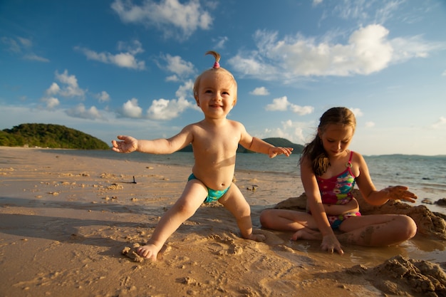 Twee zussen spelen op een zandstrand