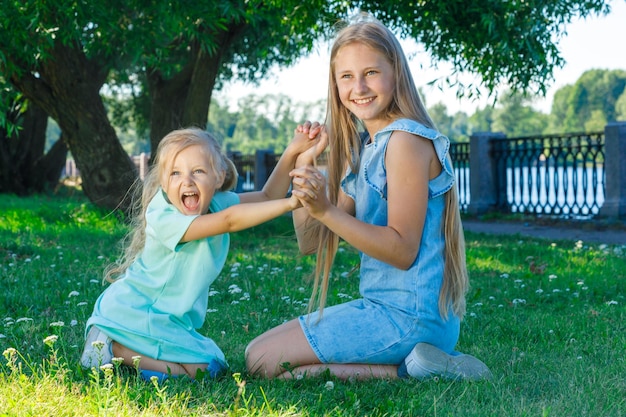 Twee zussen spelen samen in het park op het gras