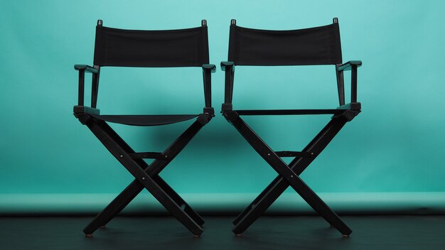 Twee zwarte regisseursstoelen op groen of Tiffany Blue of mint background.it gebruiken in videografie of filmcinema-industrie