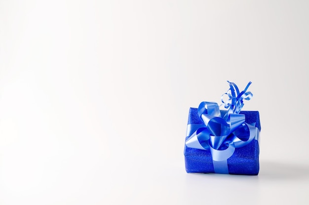 Tweede kerstdag kerstcadeau in blauw glanzend papier met blauw lint op een witte achtergrond