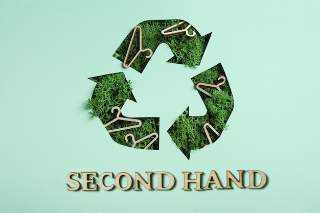 Tweedehands tekst en groen mos onder papier gesneden recycling symbool Save planet eco recycling cloth concept