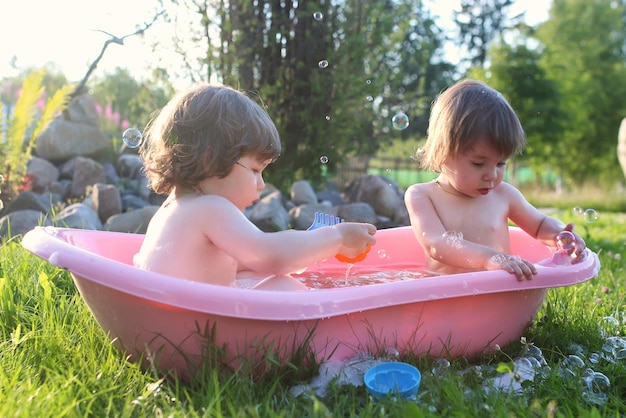 Tweeling jongen en meisje in badwater buiten