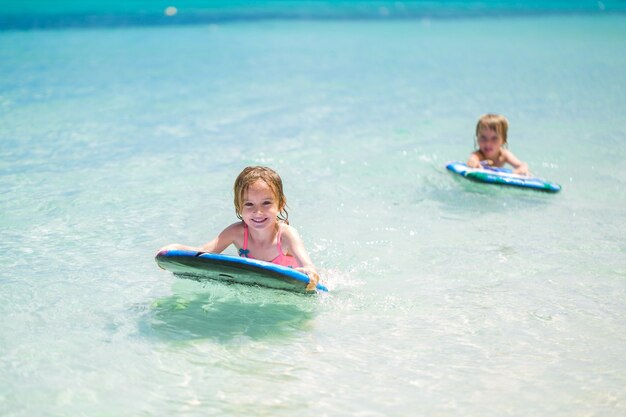 Tweelingbroer en zus om plezier te hebben met surfen in de oceaan