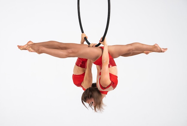 Foto tweelingen vrouwelijke circusartiest op de luchtfoto hoepel geïsoleerd op wit. zeer flexibele en professionele gymnasten.