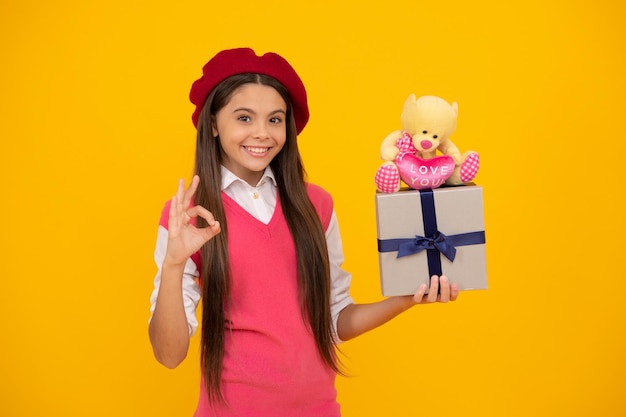 Tween and youth purchase a gift ok gesture happy french teen girl hold present box