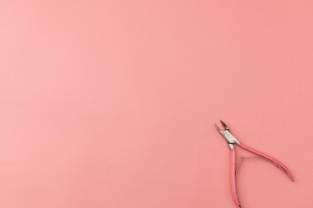 Tweezers for hands pink on pink background monochrome