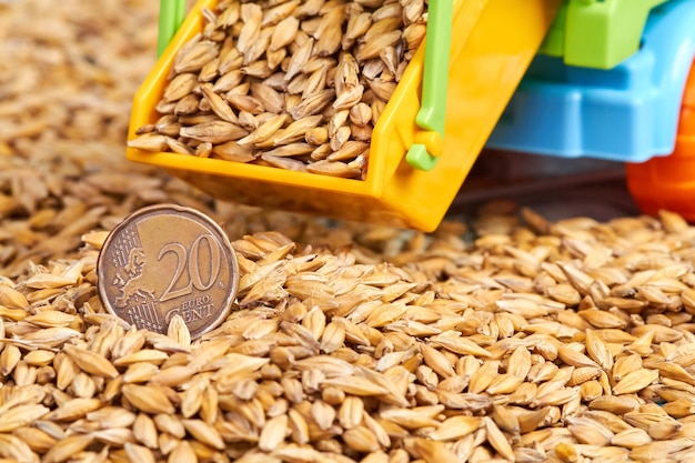 Twenty cent euro coin in barley grains with a toy truck body