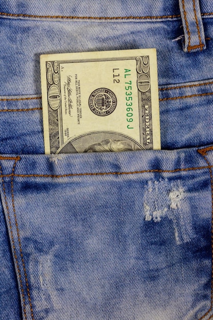 Twenty dollars bill in the pocket of blue jeans