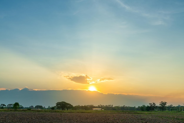 田園地帯またはビーチのトワイライトブルーの明るいオレンジ色の黄色の劇的な夕焼け空白い雲の空気の背景とカラフルなcloudscapeテクスチャ