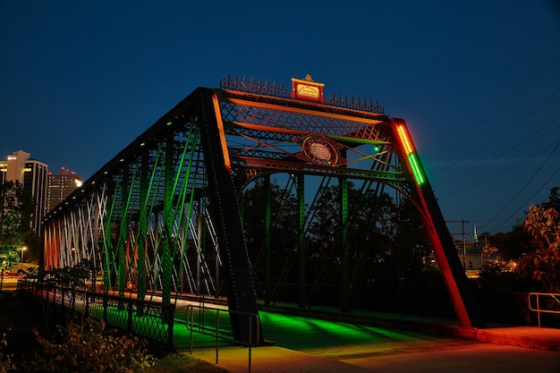 Сумерковая иллюминация оранжевый и зеленый исторический мост Уэллс-стрит Форт-Уэйн