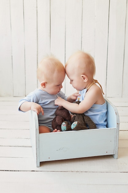 twin boys in blue pajamas with teddy bears