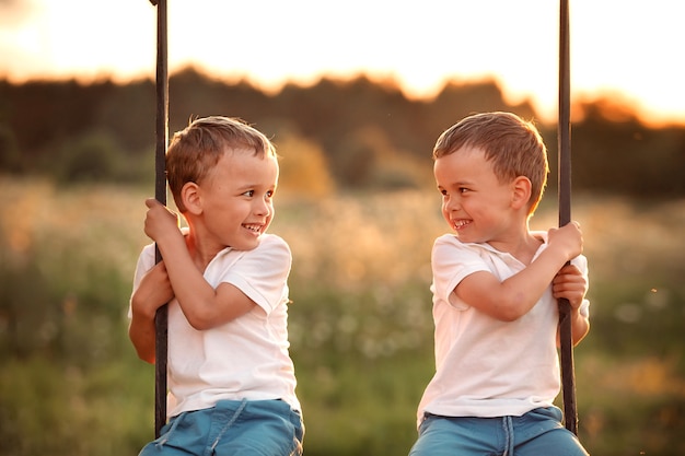 Photo twin brothers on a swing