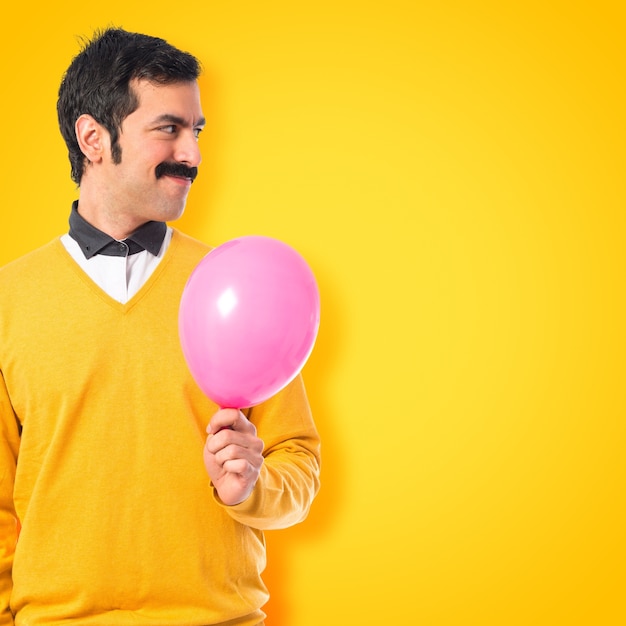 Twin brothers with balloons on colorful background