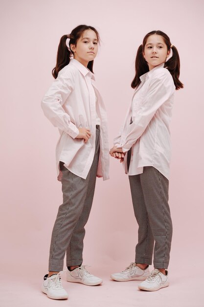 Twin girls in white shirts black and white patterned pants