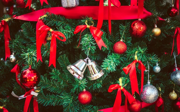 Twin silver bells and red ribbon with red Christmas balls adorn on Christmas tree Christmas