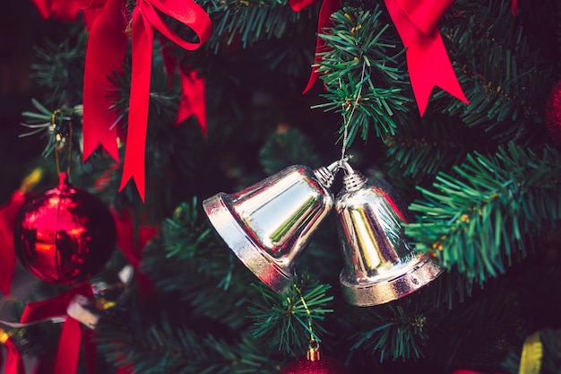 Twin silver bells and red ribbon with red Christmas balls adorn on Christmas tree Christmas