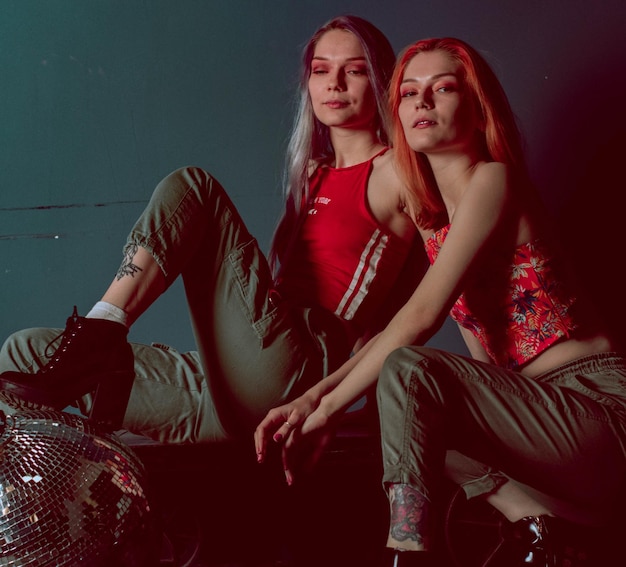 Photo twins sisters in joggers and red tops