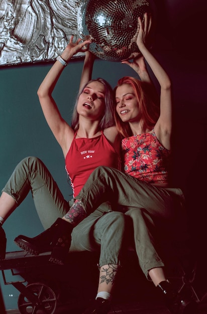 Photo twins sisters in joggers and red tops