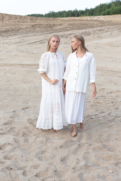 Twins with long blond hair posing at a sand quarry