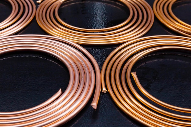 Twisted new copper tubes on a black background