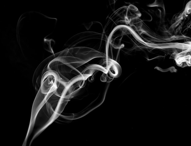 Скрученные шлейфы движения дыма на черном фоне Абстрактные линии дыма