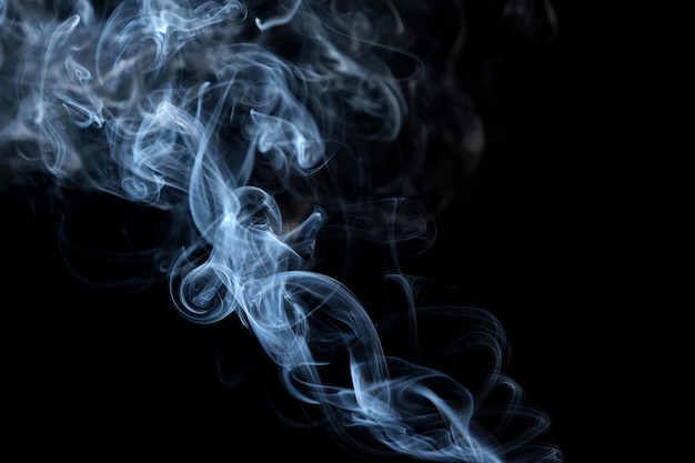 Twisted plumes of smoke smoke movement on a black background Abstract smoke lines