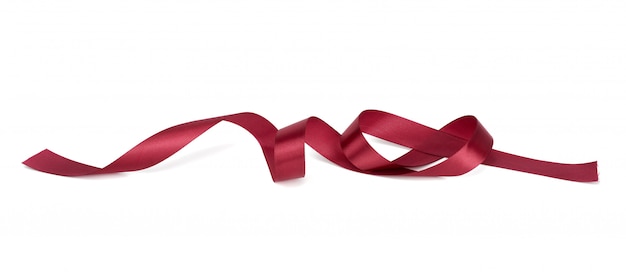 Twisted red silk ribbon with bends isolated on white wall