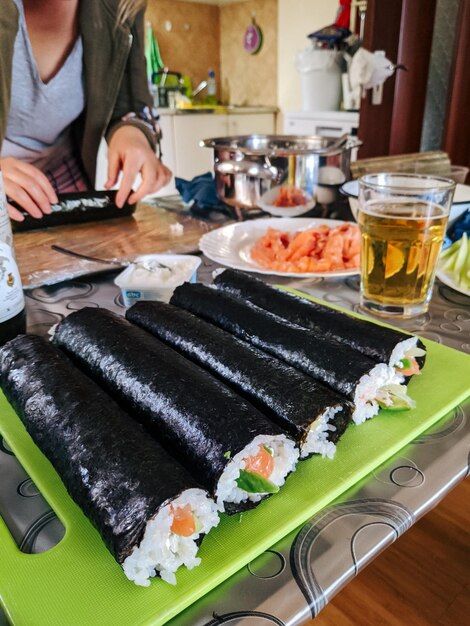 Twisted sushi rolls lie on a board in the kitchen