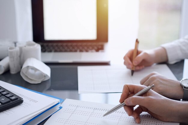 Two accountants use a laptop computer for counting taxes or revenue balance Business audit and taxes concepts