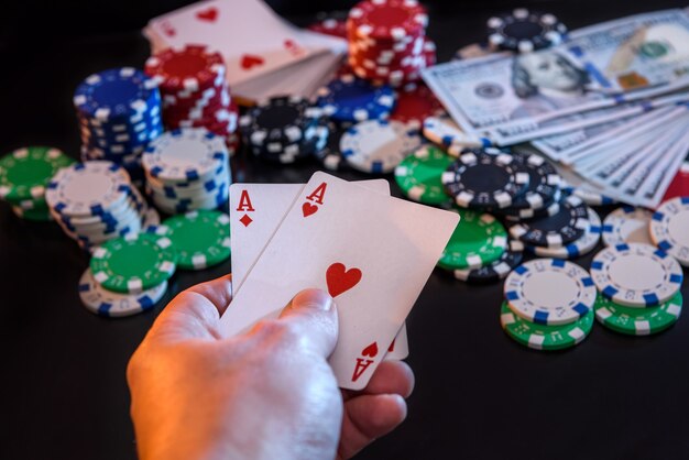 Two  aces in hand and gambling chips at black