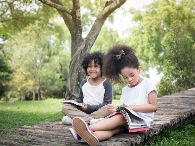 Two adorable kids reading a book