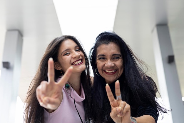 Two adult Latin American women mother and daughter with positive attitude having fun in front of the camera Concept generations and mother's day