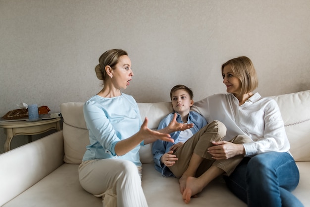 Two adult women and a child are sitting smiling.