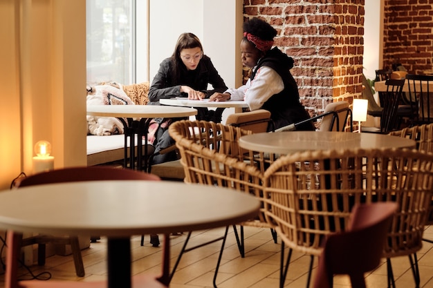 Two affectionate girlfriends choosing lunch in menu