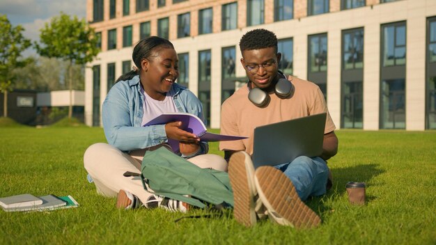Двое афроамериканских друзей, учащиеся средней школы в парке, учатся вместе, одноклассники в университете.
