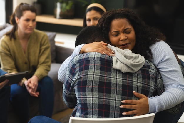 Фото Двое афроамериканских друзей, мужчина и женщина, обнимаются на сеансе терапии.