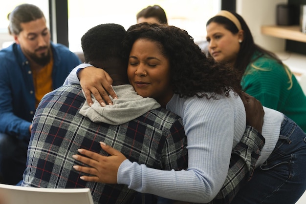 two african american male and female friends hugging on therapy session