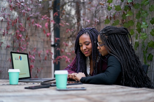 Две афроамериканские женщины сидят на террасе снаружи