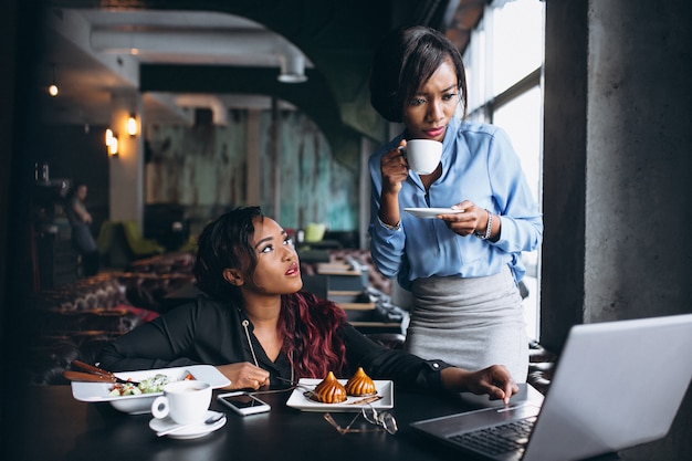 Two african american women with laptop and lunch