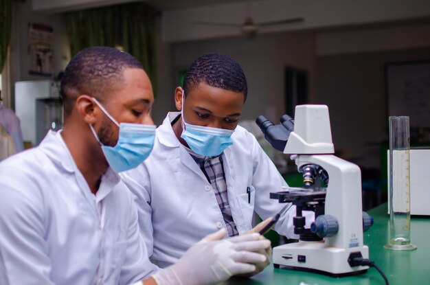 Two african doctor using their cellphone as they go through the internet