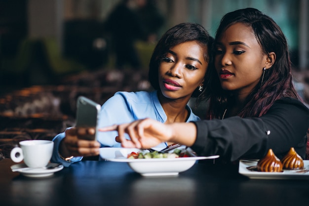 Две афро-американские женщины в кафе на обед